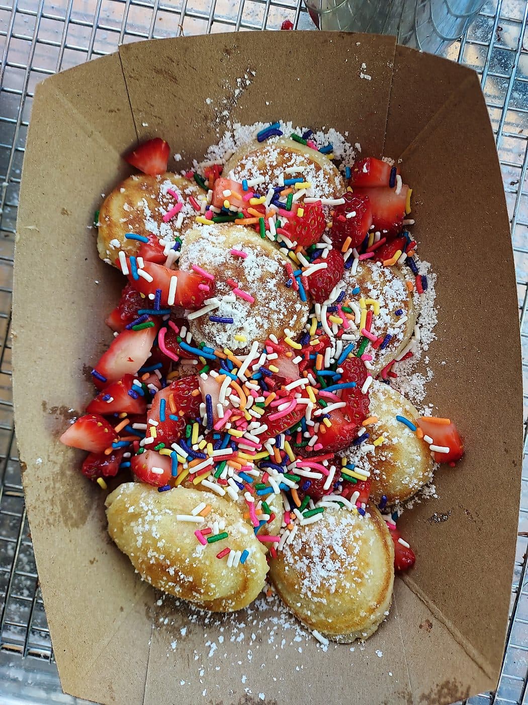 Mini pancakes with fresh strawberries and sprinkles served at a wedding dessert station