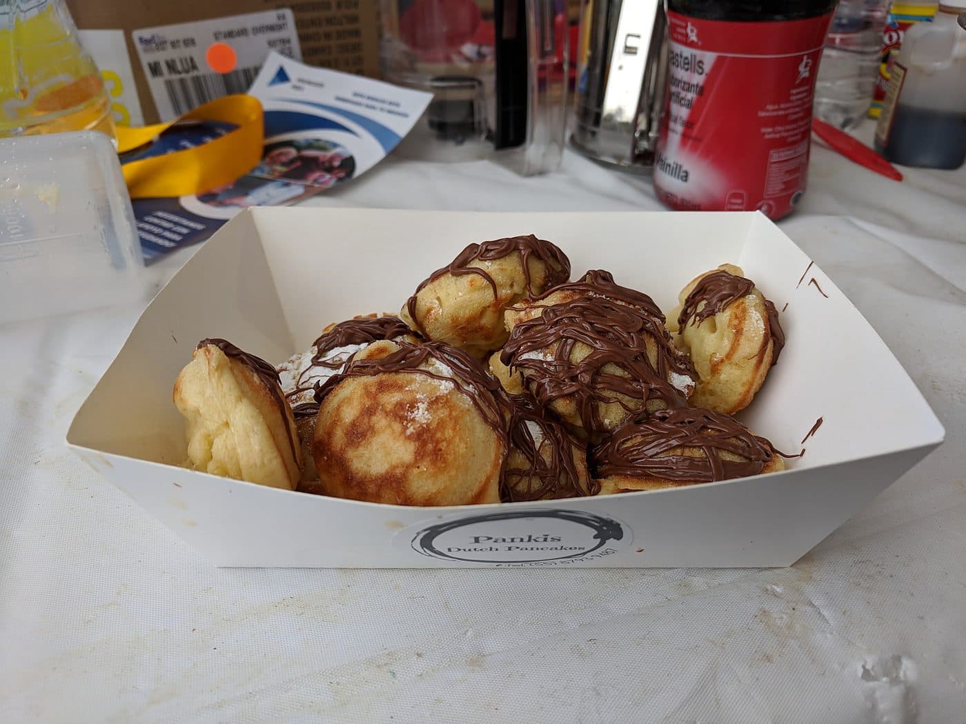 Pankis branded serving boat filled with chocolate-drizzled mini pancakes