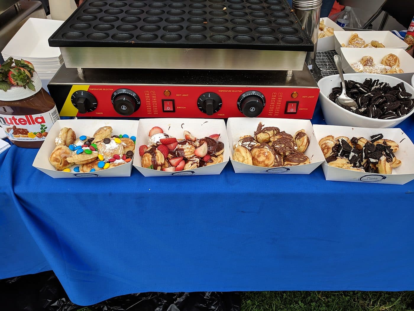 Pankis mini pancake station with griddle and four boats of topped Dutch poffertjes