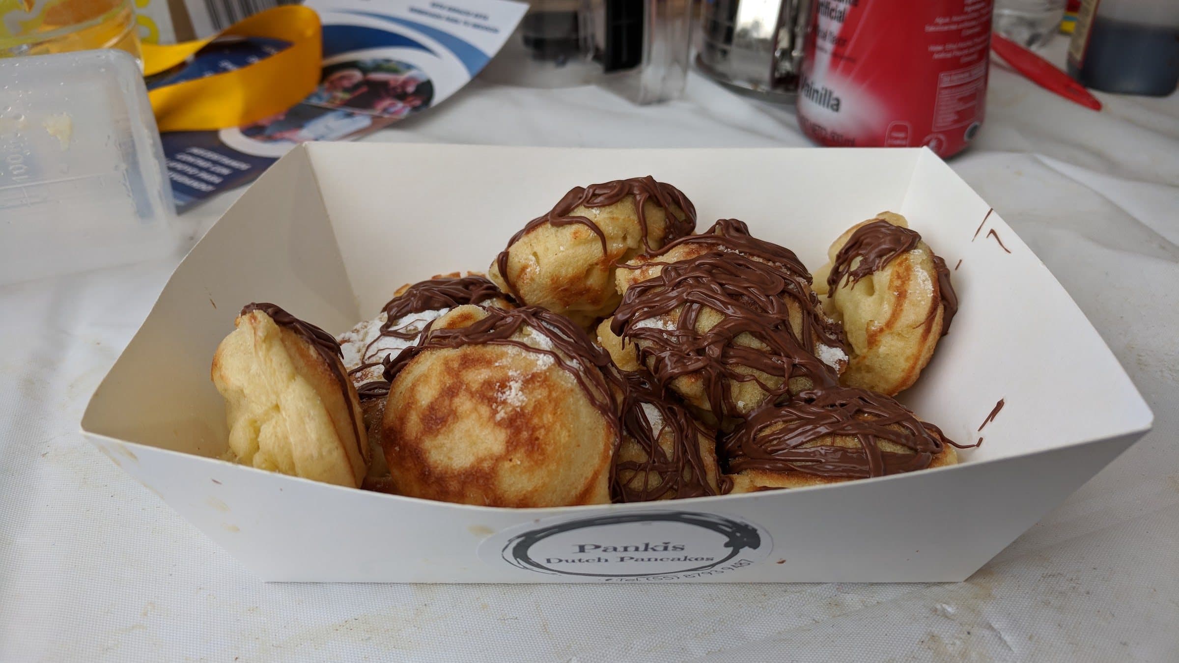 Pankis Dutch Pancakes branded serving boat filled with chocolate-drizzled mini pancakes
