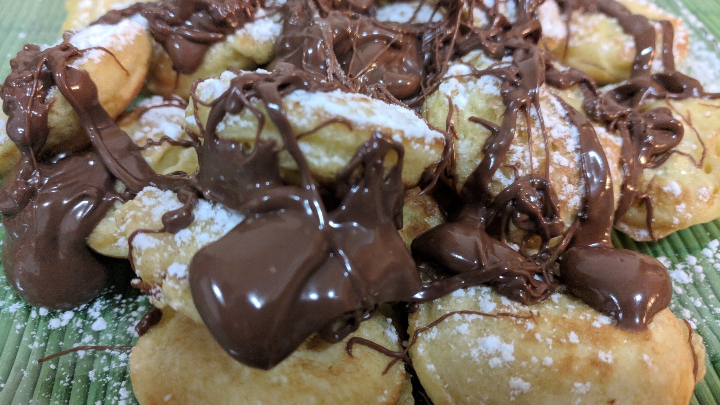 Warm Dutch mini pancakes covered in melted chocolate hazelnut spread
