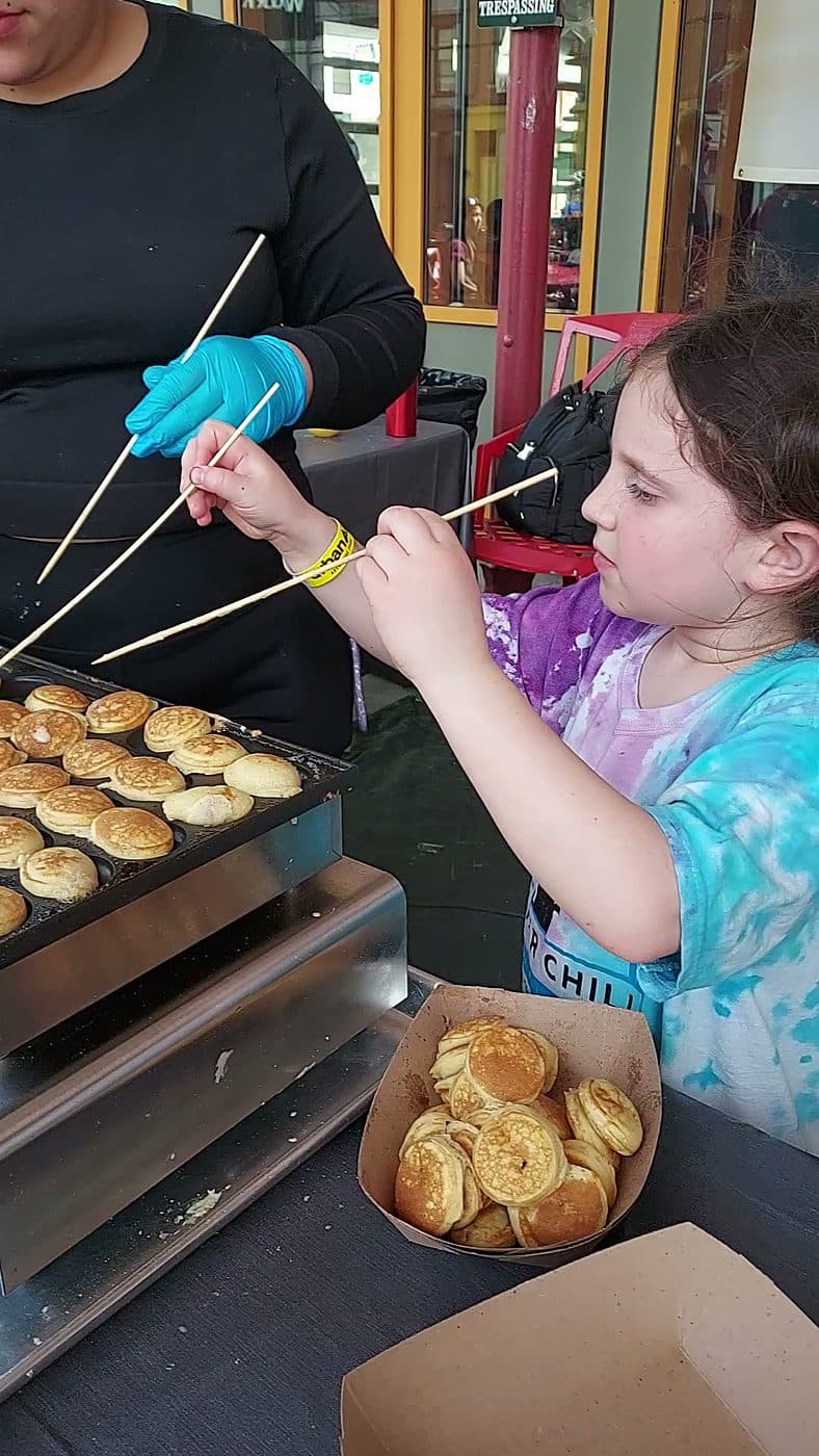 A guest taking mini pancakes straight off the griddle at a live Pankis dessert station