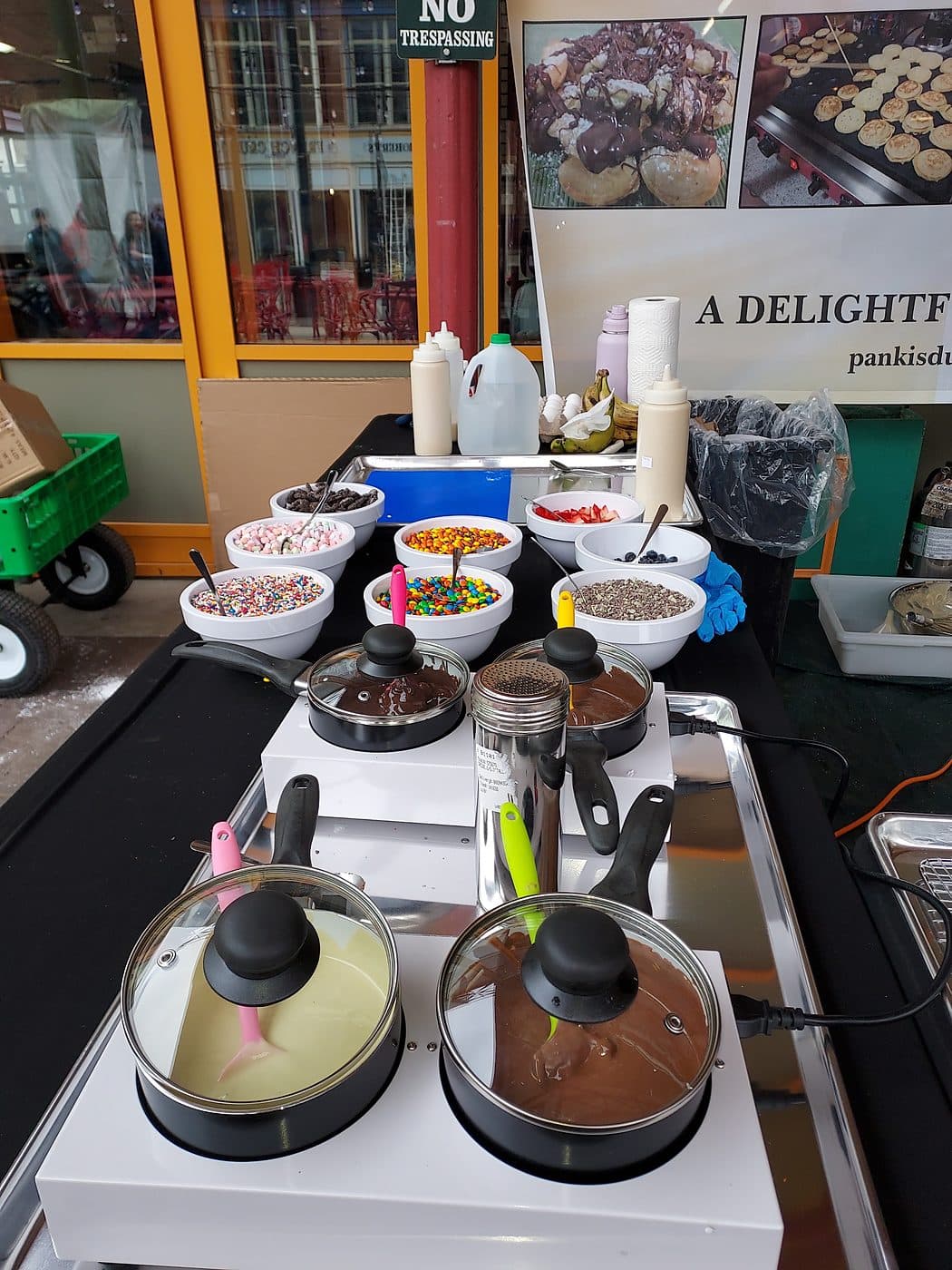 Mini pancake cart set up with toppings and sauces at an outdoor Cincinnati event