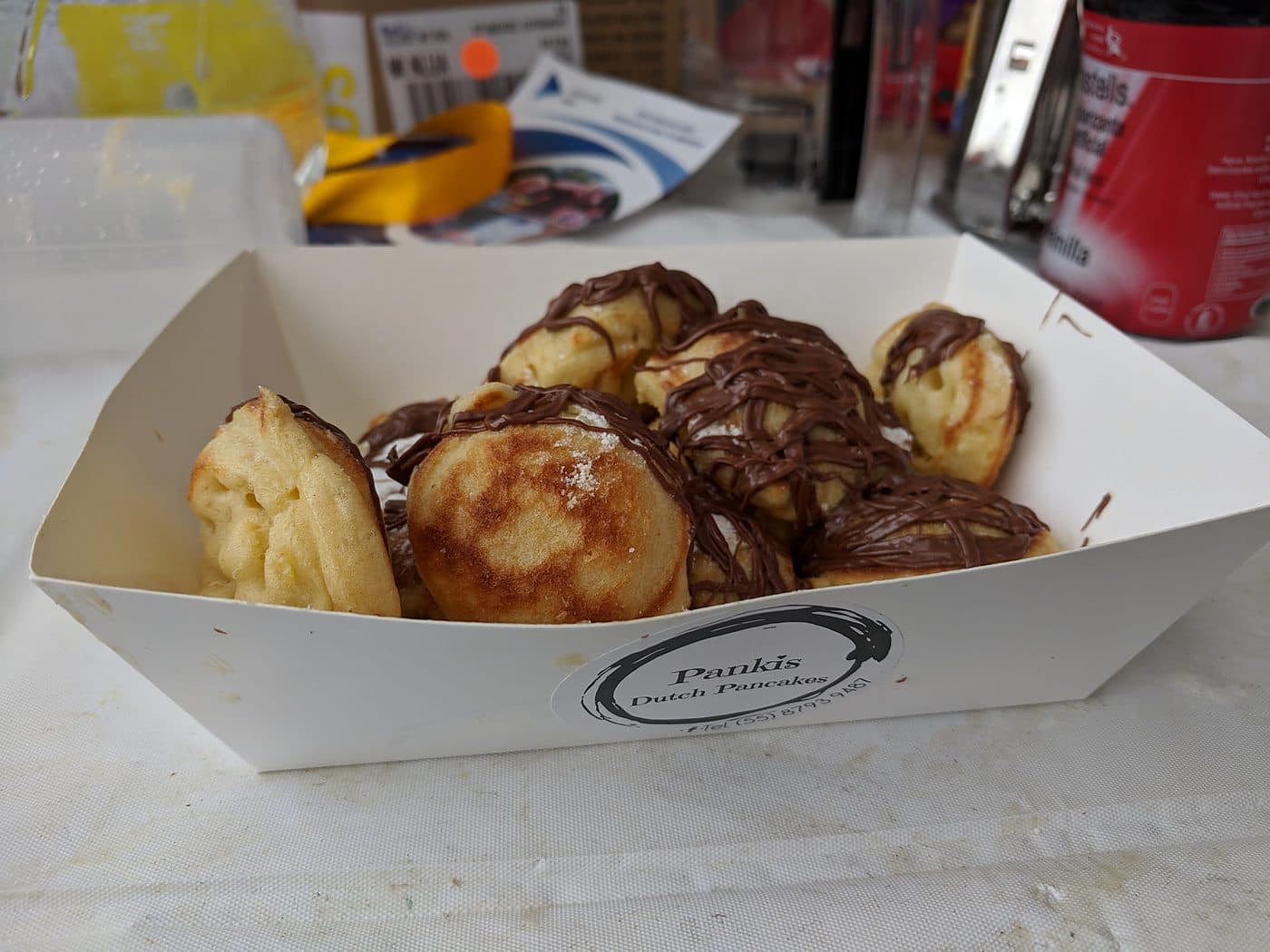 Dutch mini pancakes with chocolate drizzle in a Pankis branded serving boat