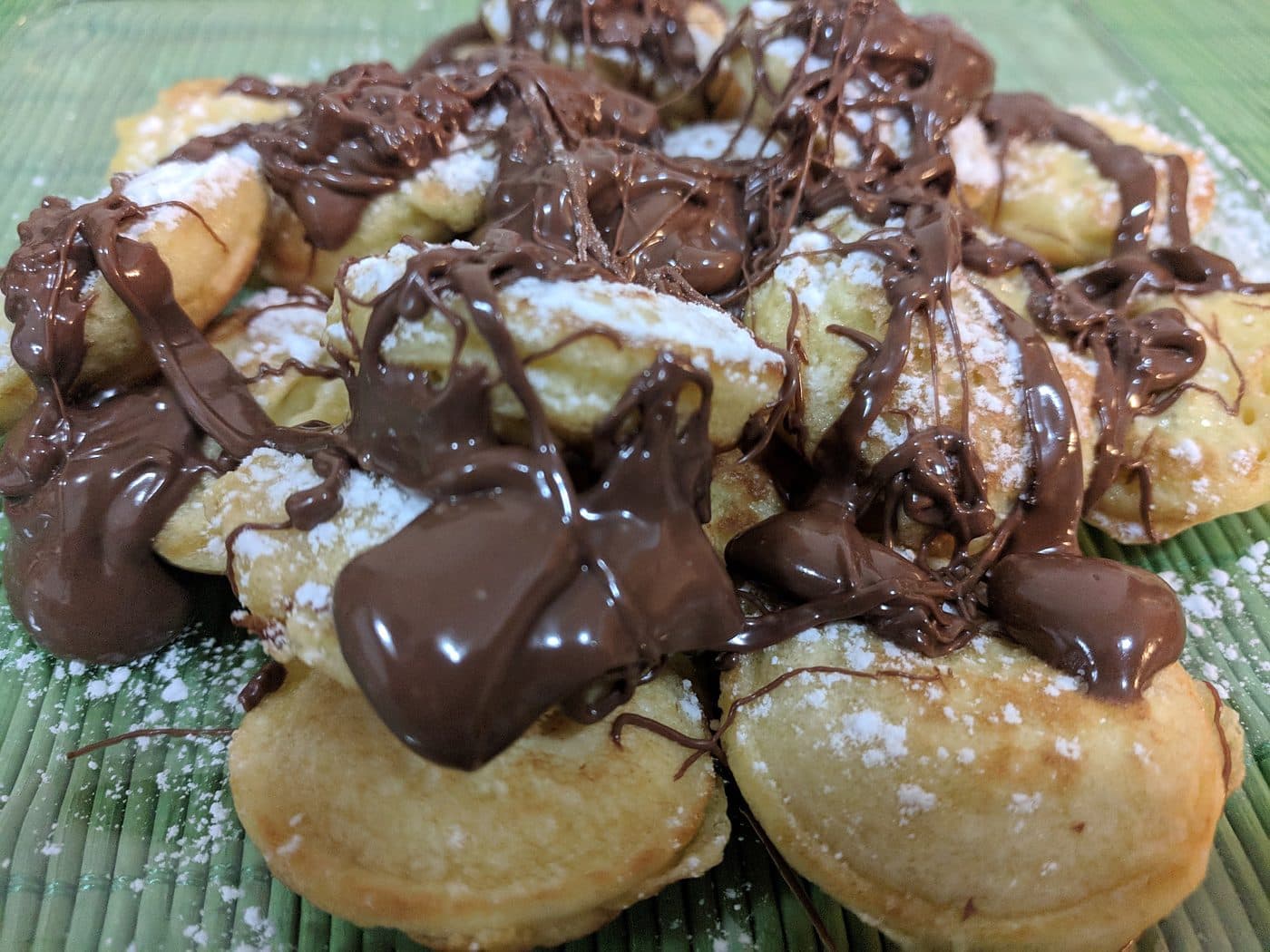 Warm Dutch mini pancakes covered in melted chocolate hazelnut spread