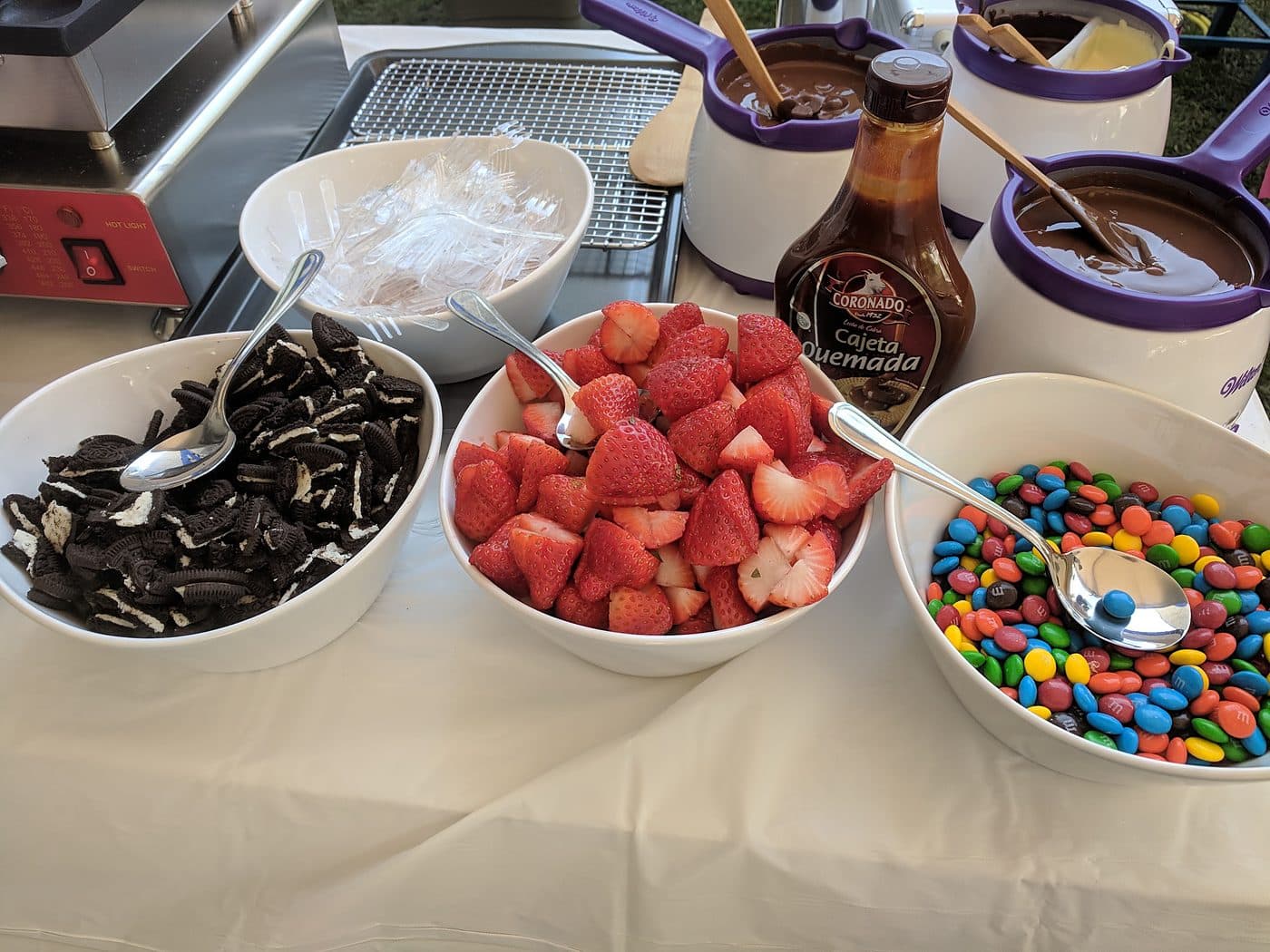 Wedding dessert toppings bar with Oreos, strawberries and M&M's